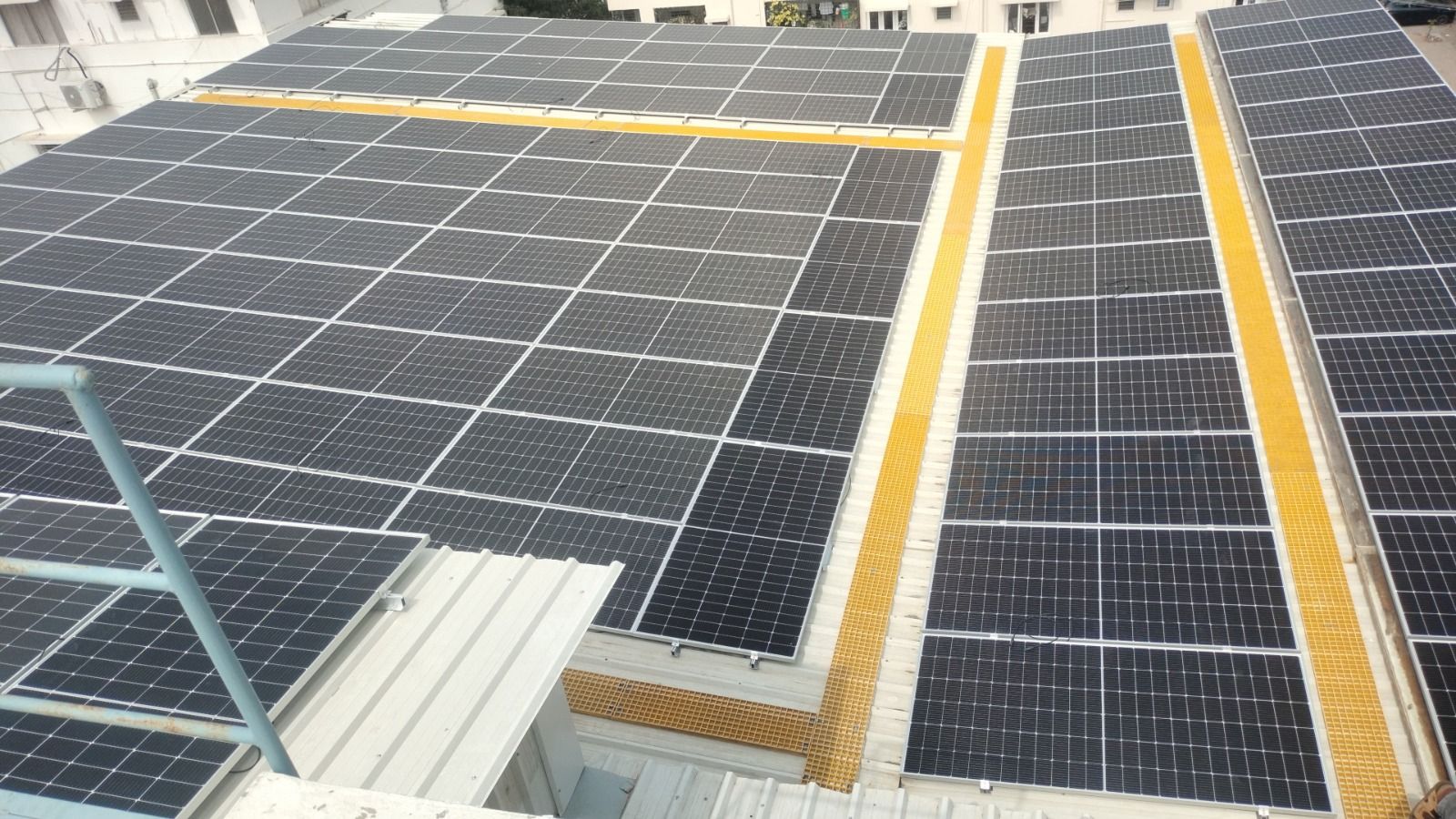 Rows of Powergate panels on a commercial sheet roof with yellow walkways